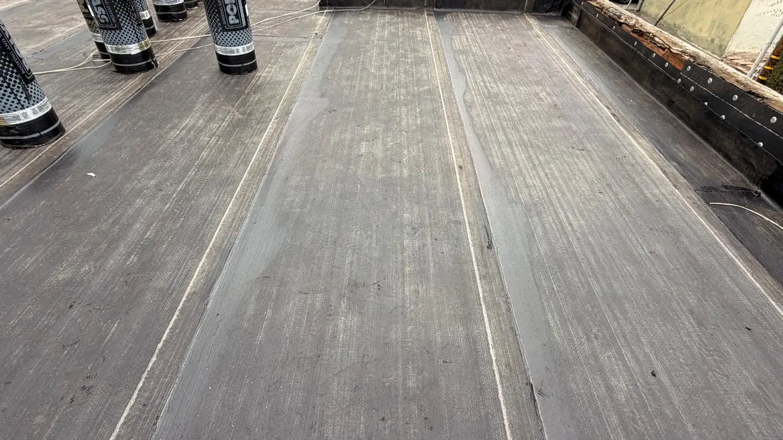 Nailed base sheet and smooth torch-down layer on a Los Angeles apartment building flat roof