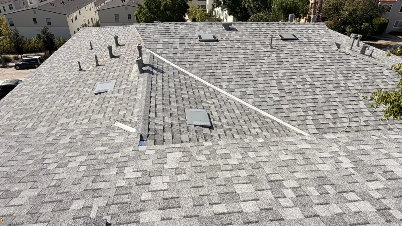 Finished apartment building roof replacement in Los Angeles: new gray Owens Corning cool roof shingles, skylights and vents
