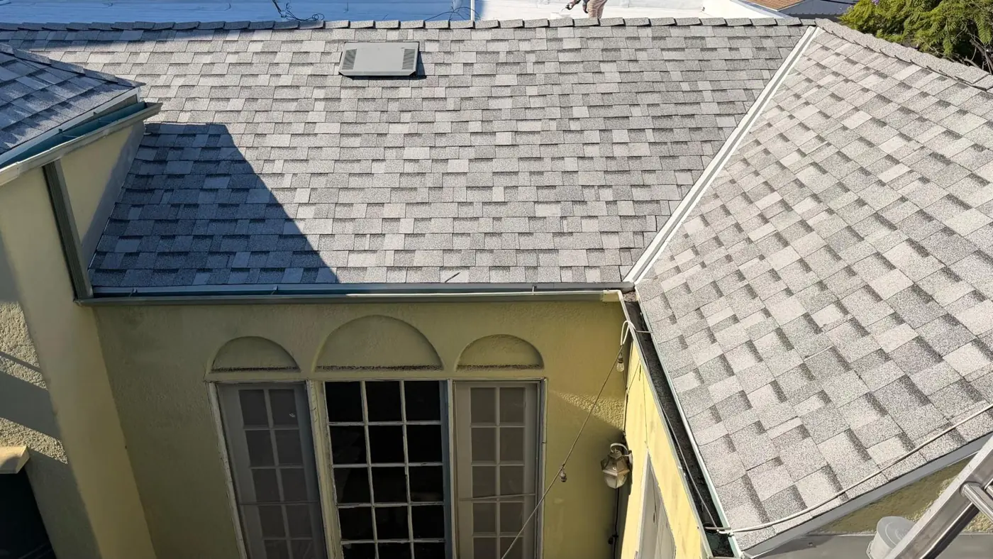 New gray shingles and clean drip edge above the arched windows of a Los Angeles apartment building