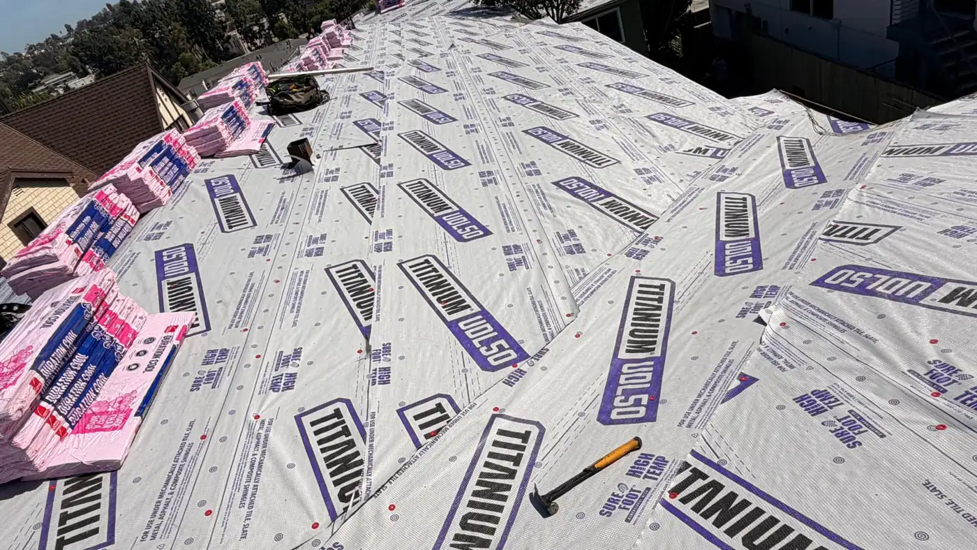 Owens Corning Duration COOL shingle bundles staged on new underlayment on a Los Angeles apartment roof