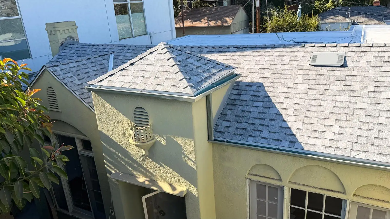 New gray Owens Corning Duration COOL shingles over the arched windows of a Spanish-style apartment building in Los Angeles