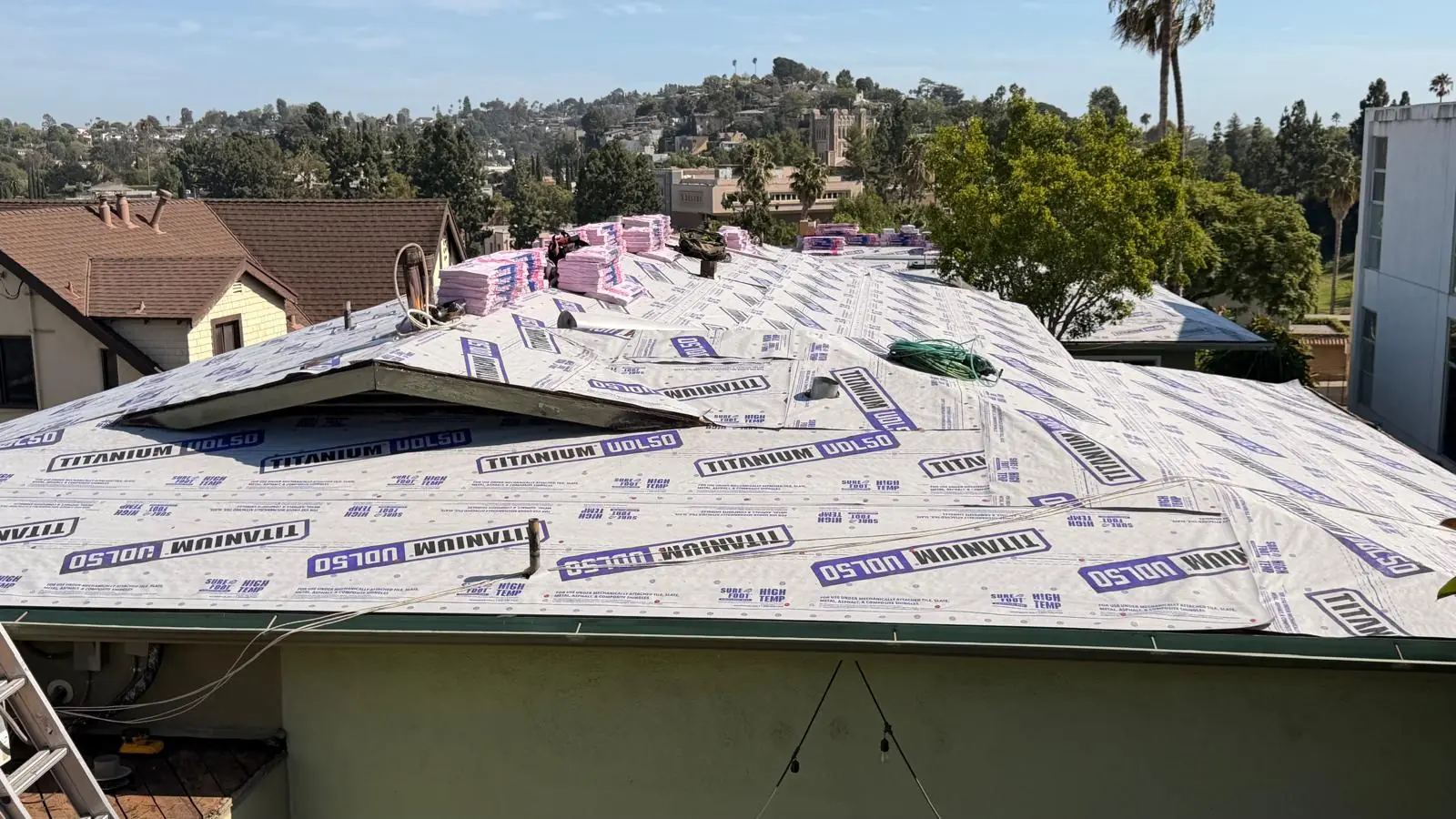 Titanium UDL50 synthetic underlayment covering a hip roof on a Los Angeles apartment building before the shingles