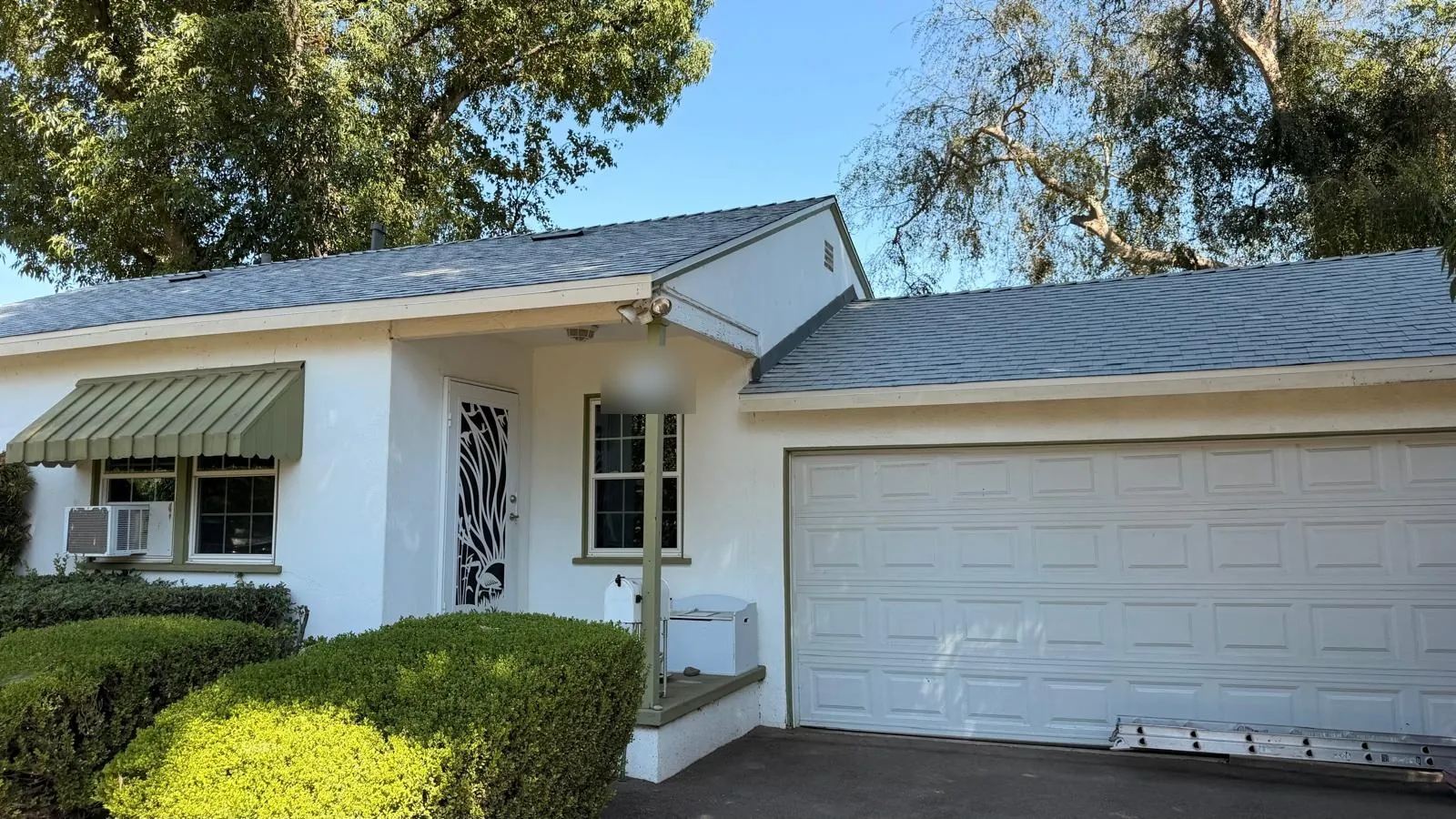 Front entry and garage of a Northridge home under new white cool roof shingles