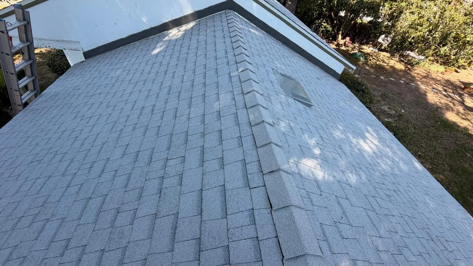 Hip ridge where two slopes of new Shasta White shingles meet on a Northridge roof