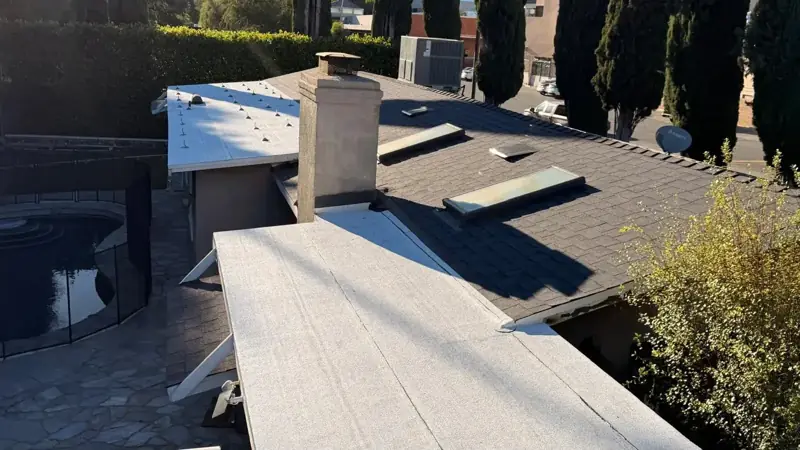 New dark cool roof shingles and a white flat roof on an Encino home, built before its solar panels went on