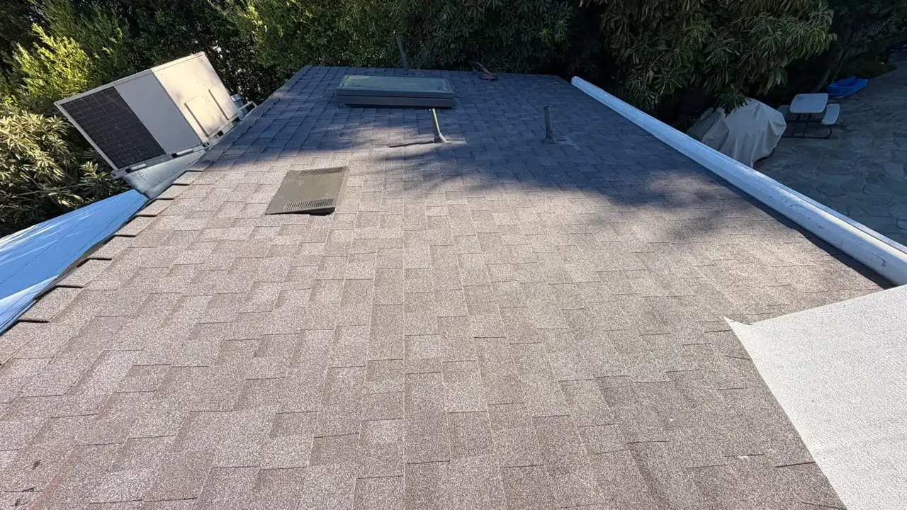 Dark Owens Corning shingles around a skylight and roof vent on an Encino home